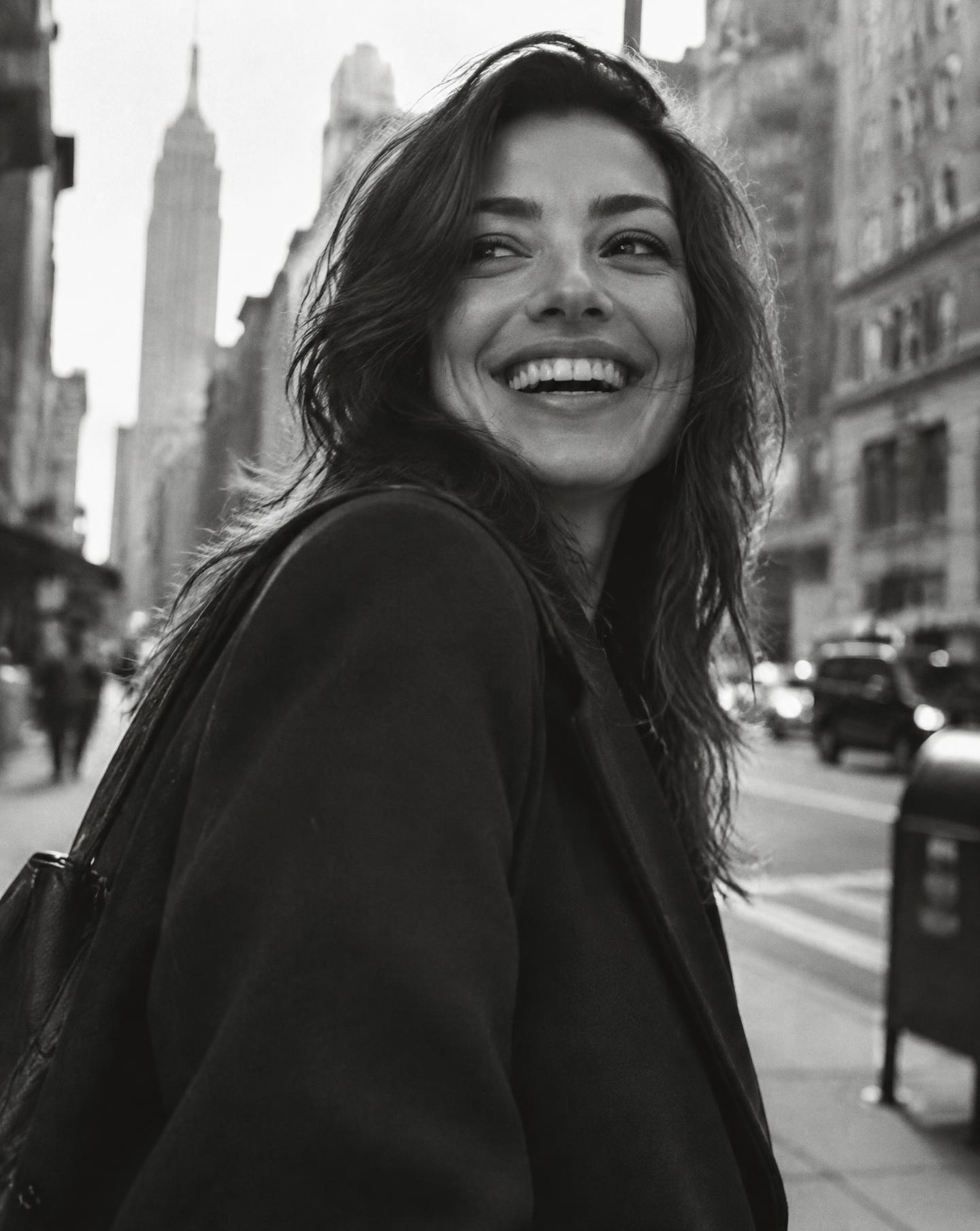 Original We Almighty hero portrait of a smiling woman on a city street, in black and white